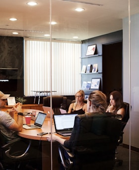 people sitting near table with laptop computer